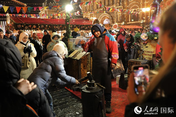 游客在新年集市上體驗(yàn)制作紀(jì)念幣,。人民網(wǎng)記者 隋鑫攝